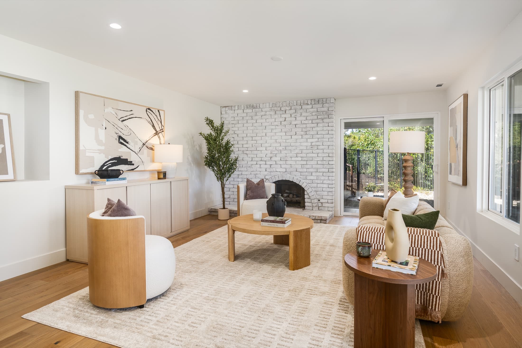 481 Montcrest Place. The lower living room, with a whitewashed brick fireplace and sliding doors to the pool terrace.
