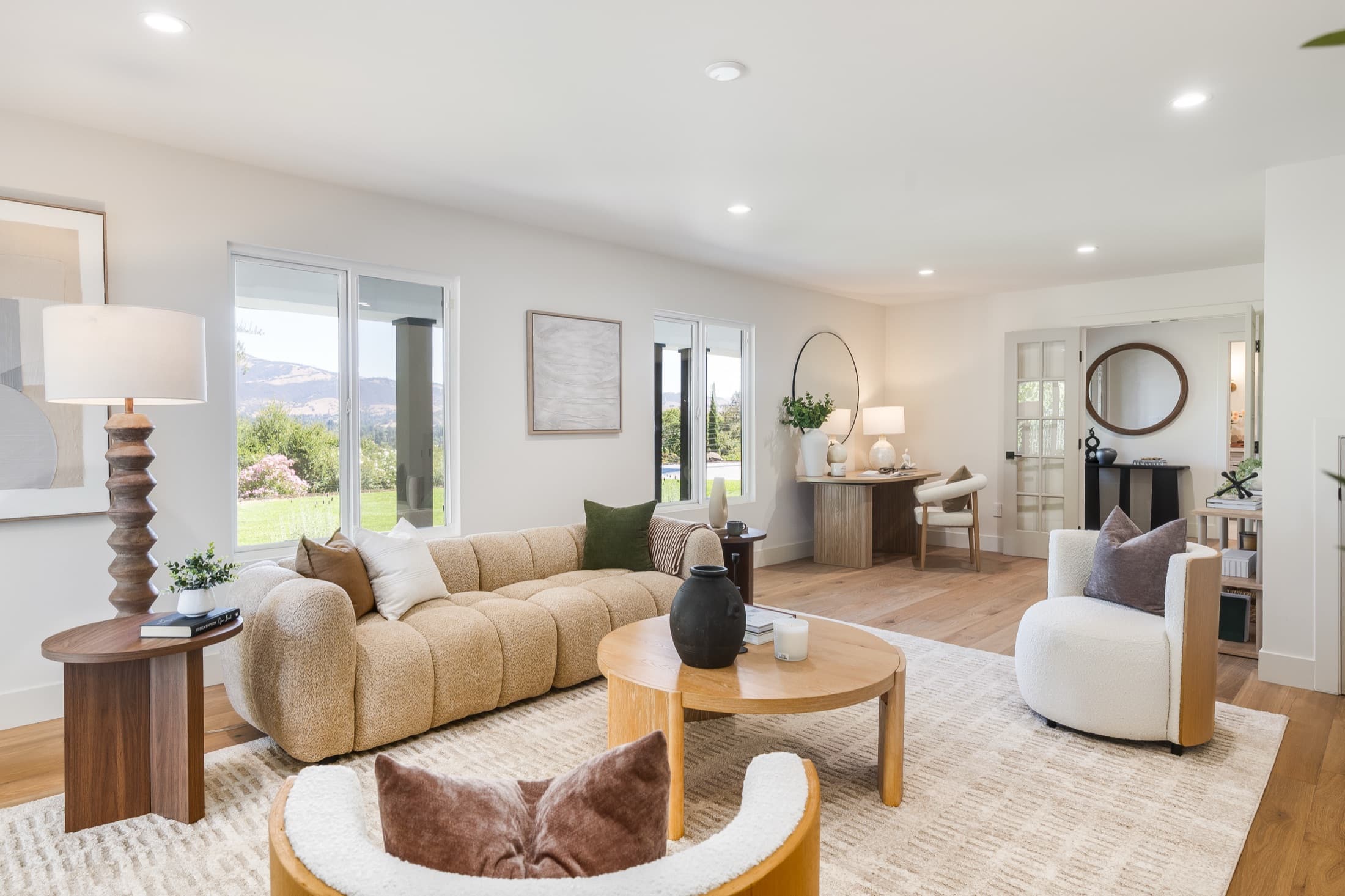 481 Montcrest Place. A living room in white oak and white plaster, opening to the lawn and the hills.