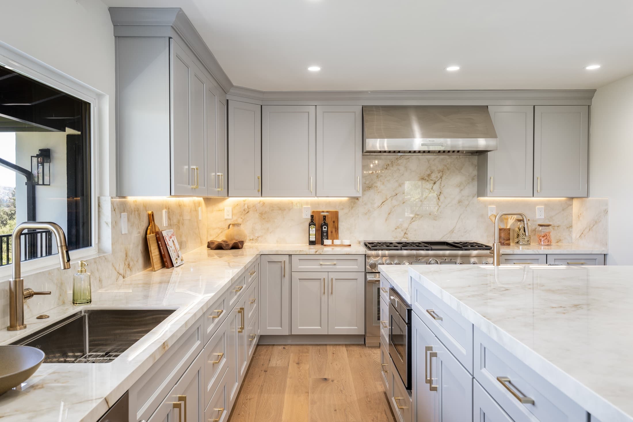 481 Montcrest Place. Full-slab stone run to the ceiling behind the range, under-cabinet light on the counters.
